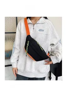 Detail view of stylish black and orange nylon waist bag with neon zipper pulls and strap