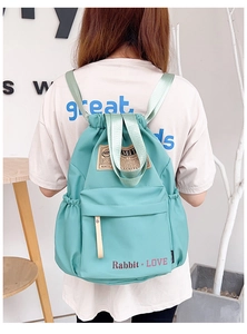 Détail d'un sac à dos cordon en nylon vert menthe avec poche frontale et logo de marque