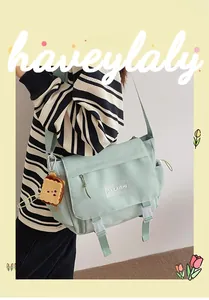 Détail du sac messager en nylon vert menthe avec rabat et pendentif toast mignon