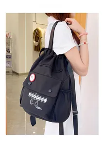 Dettaglio dello zaino nero impermeabile con coulisse, tasca con patta magnetica e grafica a orso