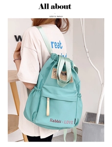 Détail du sac à dos en nylon vert menthe avec cordon de serrage et poche zippée