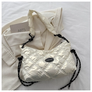 Detail of white quilted puffer bag featuring a glossy finish and braided rope strap