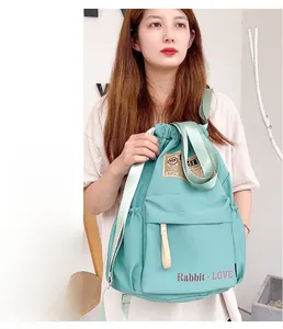 Sac à dos en nylon vert menthe à cordon avec poche avant et lettrage rouge élégant