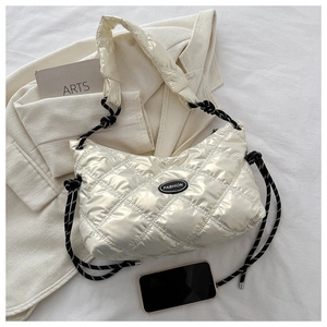Detail of quilted glossy bag featuring a Fashion label and bicolor rope shoulder strap