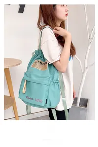 Détail du sac à dos en nylon vert menthe avec poche zippée et poches latérales élastiques
