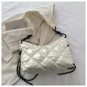 Close-up of cream white quilted puffer bag with glossy metallic texture and rope strap