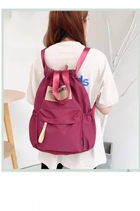 Détail du sac à dos bordeaux à cordon en nylon résistant à l'eau avec design à empiècements