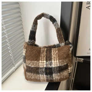 Detailansicht der weichen Plüschstruktur mit Karomuster auf dieser Herbst-Handtasche