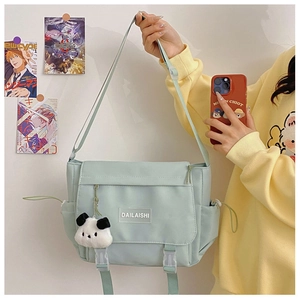 Détail du sac messager en nylon vert menthe avec sangle et pendentif panda