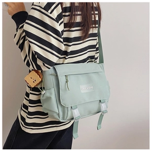 Vue détaillée du sac bandoulière vert menthe avec étiquette blanche et pendentif toast