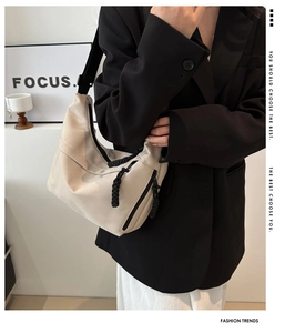 Minimalist beige hobo bag with unique black rope woven zipper pull detail on model