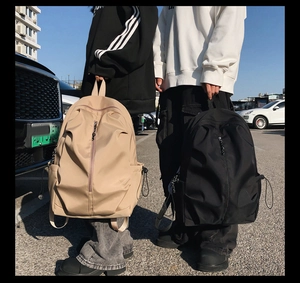Side view of black and beige waterproof nylon backpacks with drawstring side pockets