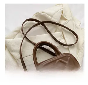 Close-up of the elegant diamond quilted leather and comfortable strap on a brown tote