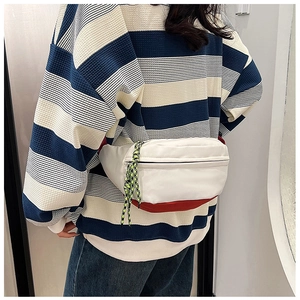 Detail of a casual waist bag with white and red contrast design on a model back