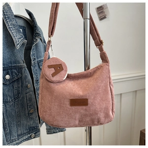 Detail of pink corduroy crossbody bag with removable coin pouch and fashion label