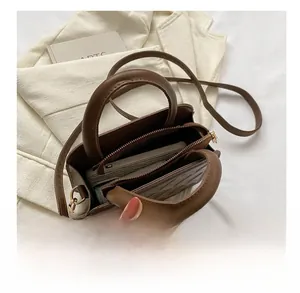 Detail showing the inner capacity of this brown diamond pattern crossbody bag with essentials