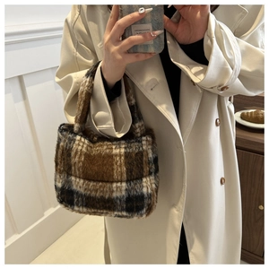 Detail einer karierten Plüsch-Handtasche in Braun und Weiß mit weichem Webpelz