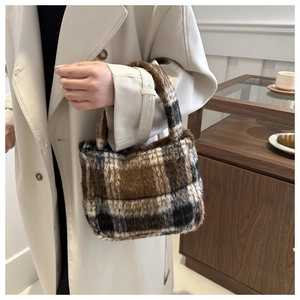 Detail der weichen Plüschtextur der braun-beige karierten Schultertasche