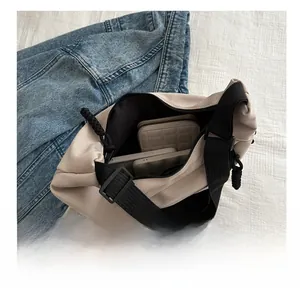 Top view showing the large interior capacity of this beige canvas shoulder bag with black strap