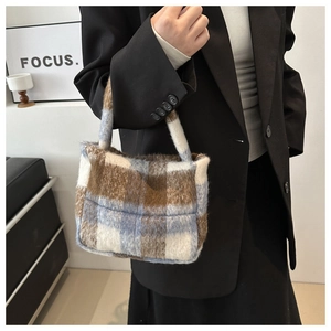 Detail der blau-braun karierten Plüschhandtasche mit Fokus auf Textur am Model