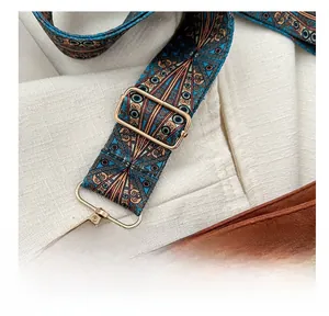 Detail of adjustable ethnic style bag strap with colorful weaving and gold hardware