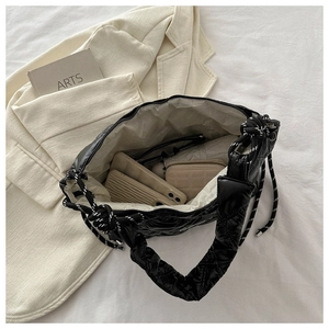 Detail view of the spacious interior of a black quilted down-style tote with drawstring closure