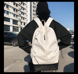 White minimalist synthetic leather backpack featuring a center zipper and adjustable straps