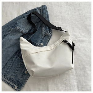 Detail of white nylon crescent bag showing the adjustable black strap and smooth texture