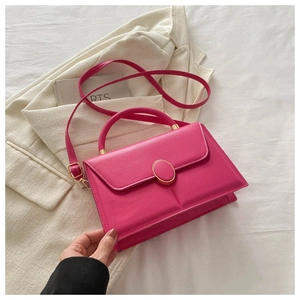 Detail view of fuchsia leather handbag with metal buckle and elegant crossbody strap
