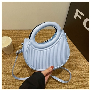 Nahaufnahme hellblaue Handtasche mit vertikaler Streifentextur und Rundgriff