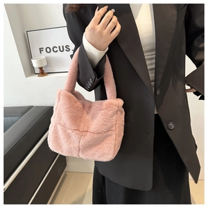 Detail der rosa Plüschhandtasche mit gestepptem Karomuster und weicher Textur