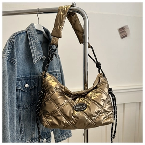 Detail of champagne gold quilted puffer bag featuring fashion tag and nylon cord strap