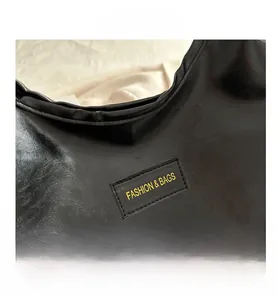 Detail of black lychee grain leather handbag featuring yellow Fashion & Bags logo tag