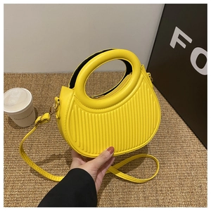Makroaufnahme einer gelben halbkreisförmigen Handtasche mit vertikaler Streifentextur