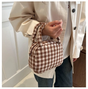Dettaglio della borsa tote vintage a quadri marroni e bianchi con trama in tweed