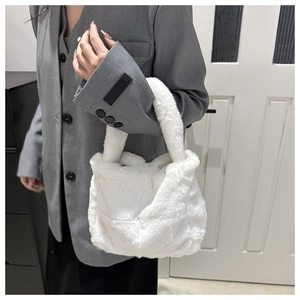 Nahaufnahme der weichen weißen Kunstfell-Handtasche mit flauschigen Tragegriffen am Modell
