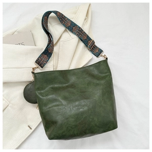 Detail of dark green retro shoulder bag with bohemian printed wide strap and coin pouch