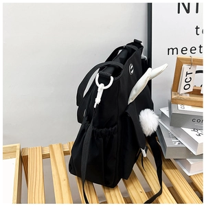 Dettaglio borsa tote in nylon nero con orecchie di coniglio bianche e pompon soffice