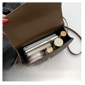 Interior view showing capacity for phone and makeup in brown crocodile texture bag