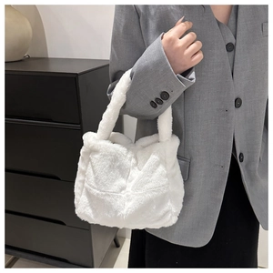 Detailansicht der weißen flauschigen Plüschtasche mit weicher Textur und Henkel am Modell