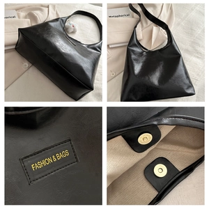 Detail view of large black tote bag featuring magnetic closure and fabric logo patch