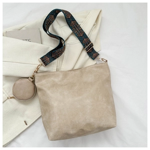 Detail of light beige bucket bag with ethnic geometric strap and small round coin purse
