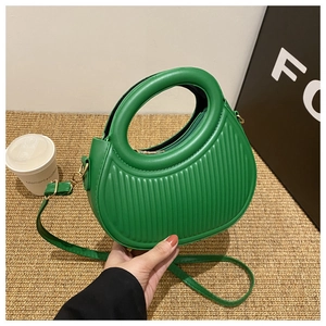 Detail der grünen gestreiften halbkreisförmigen Handtasche mit rundem Griff und Gurt