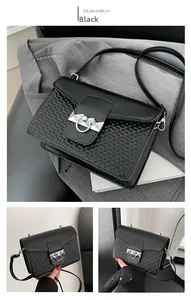 Detail showing black heart-embossed crossbody bag with silver ring and rivet accents