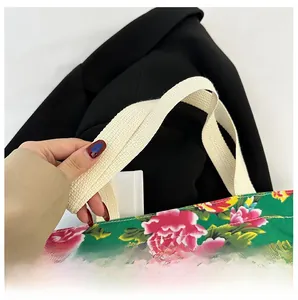 Close-up of sturdy woven shoulder strap on a green floral canvas tote bag