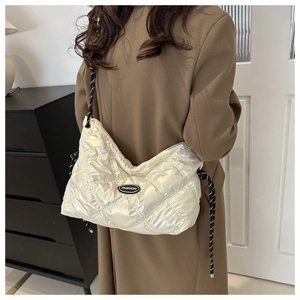 Detail of quilted glossy shoulder bag with iridescent finish and fashion tag