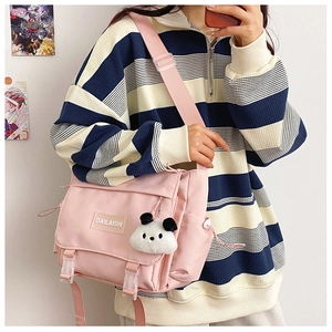 Détail du sac bandoulière en nylon rose avec un joli porte-clés en peluche de panda