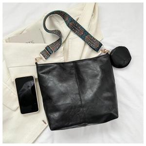 Chic black crossbody bag with vibrant bohemian strap and matching coin purse charm