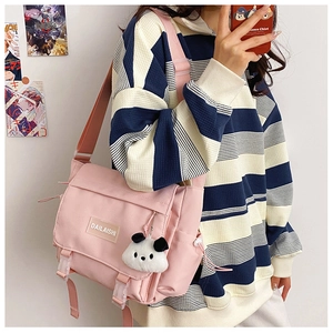 Détail du sac messager en nylon rose avec pendentif panda et étiquette de marque