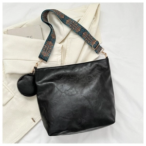 Detail view of black PU leather tote bag with ethnic embroidery wide shoulder strap